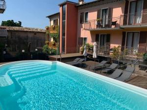 a swimming pool in front of a house at Hotel Dolomiti in Malcesine +110 photos