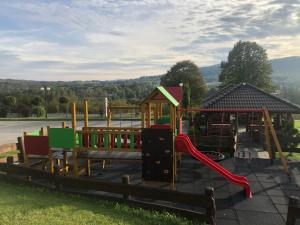 een park met een speeltuin met een glijbaan bij Hotel Arkadia in Klecza Górna