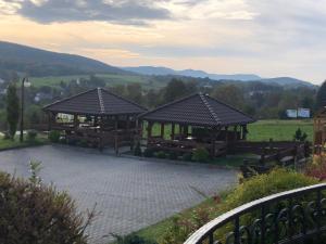 a couple of pavilions with mountains in the background at Hotel Arkadia in Klecza Górna