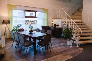 a dining room with a table and chairs and stairs at Hotel Müller in Genthin