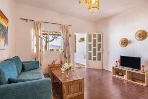 a living room with a blue couch and a tv at Casa Adonai in Tuineje