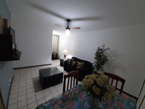 a living room with a table and a ceiling fan at Cabo Frio - Residence in Cabo Frio