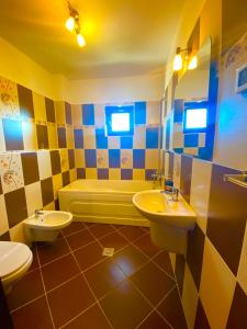 a bathroom with two sinks and a tub and a toilet at Pensiunea Soarelui in Fundata