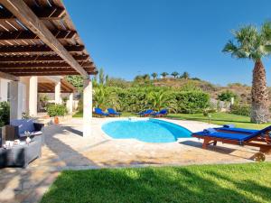 una piscina en un patio con sillas y un patio en Villa Eros Spartia Kefalonia en Spartia