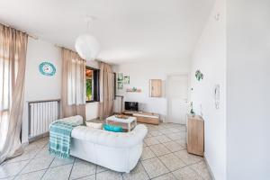 salon z białą kanapą i stołem w obiekcie Villa Alma w mieście Soiano del Lago