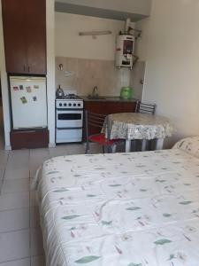 a bedroom with a bed and a kitchen with a stove at Macaripana in Gualeguaychú