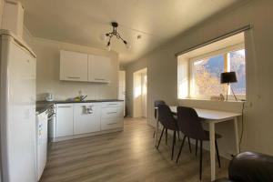 a kitchen with a table and chairs and a window at Waterfront Senja 3 in Torsken