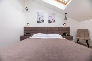 a bedroom with a large bed and a chair at M50 Apartments in Palanga