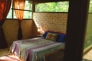 ein Schlafzimmer mit einem Bett in einem Zimmer mit Fenstern in der Unterkunft Mariri Jungle Lodge in Alto Paraíso de Goiás