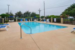 - une grande piscine avec une main courante en métal à côté dans l'établissement Comfort Inn University Wilmington, à Wilmington