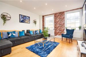 a living room with a couch and a brick wall at The Stunning Duplex Gem in The Heart of Bath in Bath