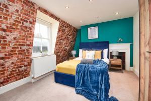 a bedroom with a brick wall and a bed at The Stunning Duplex Gem in The Heart of Bath in Bath