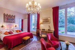 a bedroom with a bed and a desk and chairs at Le Clos d'Amboise in Amboise