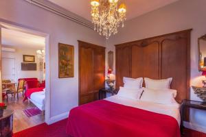 - une chambre avec un grand lit et un lustre dans l'établissement Le Clos d'Amboise, à Amboise