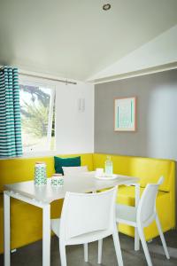 une salle à manger avec une table et des chaises blanches dans l'établissement Camping le Marache, à Biganos