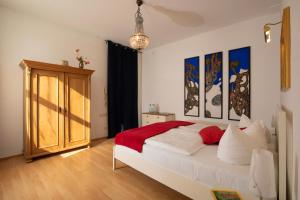 ein Schlafzimmer mit einem großen weißen Bett und Gemälden an der Wand in der Unterkunft Fürstenhof - Ferienwohnung 106 in Sassnitz