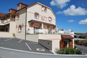 a large white building with a parking lot at Pré en Bulles in Trépail