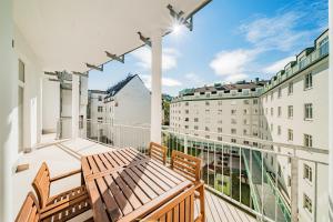 un balcón con 2 bancos de madera y 2 edificios en easy flat Margareten Apartments, en Viena