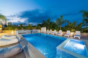 a swimming pool with lounge chairs and a swimming poolvisorvisor at Villa Green Diamond - Private Heated Pool in Platanes