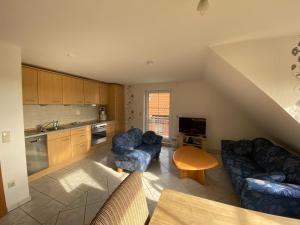 a kitchen with a couch and chairs and a table at Ferienwohnung am Deichweg in Cappel-Neufeld