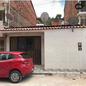 a red car parked in front of a building at Cantinho da Biu in Maragogi