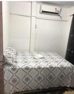 a small bedroom with a bed with a white comforter at Cantinho da Biu in Maragogi