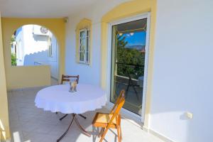 een tafel en stoelen op het balkon van een huis bij GREEN PARADISE PALAIA FoKAIA in Áyios Yeóryios