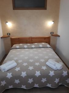 ein Bett mit zwei weißen Handtüchern darüber in der Unterkunft Appartamento In Montagna in Venas