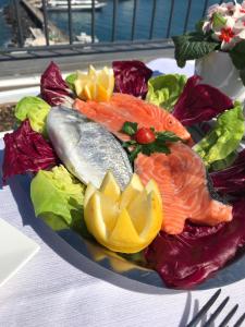 a plate of fish and vegetables on a table at Relais Maresca Luxury Small Hotel & Terrace Restaurant in Capri