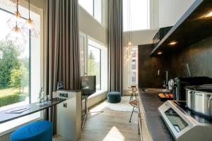 eine Küche mit einer Theke und einem Waschbecken sowie eine Küche mit Fenstern in der Unterkunft HARBR. hotel Konstanz in Konstanz