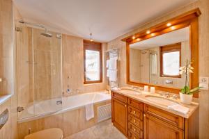 un bagno con vasca, doccia e lavandino di Chalet Zen Zermatt, 100m from Ski Lift and Piste a Zermatt Altre 17 foto