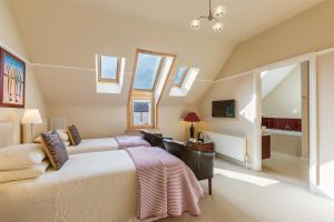 a bedroom with a bed and a desk and windows at Dún Ard in Dungarvan