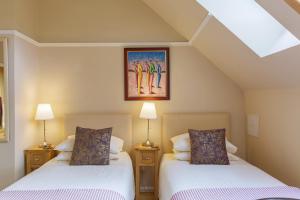two beds in a room with two lamps at Dún Ard in Dungarvan