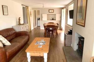 a living room with a couch and a table at Elbury Farm Annex in Exeter