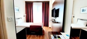 a hotel room with a bed and a television at Hotel DOA in Skopje