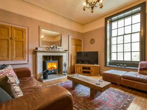 uma sala de estar com um sofá e uma lareira em The Mill Managers House em Matlock