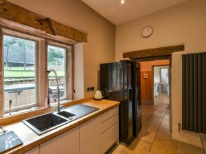 eine Küche mit einer Spüle und einem Kühlschrank in der Unterkunft The Mill Managers House in Matlock
