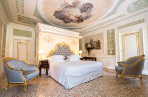 a bedroom with a bed and a ceiling with a painting at Ca' Bonfadini Historic Experience in Venice