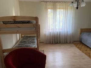 a bedroom with two bunk beds and a window at Hostel Kastaņas in Lielvārde +3 photos