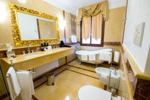 a bathroom with a sink and a toilet and a mirror at Ca' Bonfadini Historic Experience in Venice