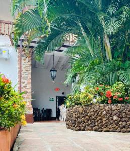 un patio con palmeras y flores en Hotel Villa Occidente, en Santa Fe de Antioquia