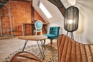 een kamer met stoelen, een tafel en een bakstenen muur bij LOCBNB - TOURISM and BUSINESS LOCATIONS - ALSACE - BARR CENTRE - ROUTE DES VINS in Barr