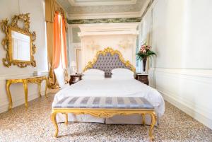 a bedroom with a bed with a gold frame at Ca' Bonfadini Historic Experience in Venice