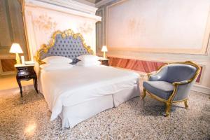 a bedroom with a king sized bed and a chair at Ca' Bonfadini Historic Experience in Venice