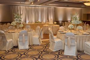 un salón de banquetes con mesas blancas y sillas blancas en Holiday Inn Dayton/Fairborn I-675, an IHG Hotel en Fairborn