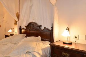 a bed with a wooden headboard and a table with a lamp at Villa Kamares Private pool in Kondomari