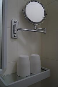a bathroom with a mirror and two white stools at 紅館客棧 in Hong Kong