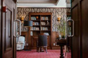 a living room with a book shelf with books at Boutique Hotel Annuska in Balatonfüred