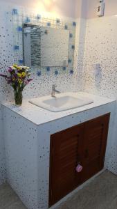 baño con lavabo y jarrón de flores en Ban Chang Klang na en Ban Nong Ap Chang