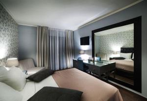 a bedroom with a bed and a desk and a mirror at Theasis Hotel Paramythia in Paramythia
